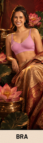Woman wearing pink lace bra with matching skirt, seated on stool in studio setting